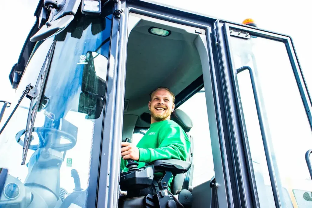 Chauffeur van TH Containers die trots uit zijn wagen kijkt